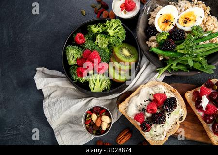 Schüsseln mit veganem Haferbrei mit Eiern und Gemüse, Sandwiches mit Obst. Gesunde Ernährung. Draufsicht. Stockfoto