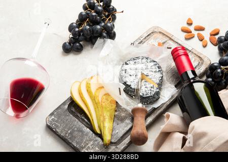 Rotwein mit Snacks. Weinglas mit Flasche, Auswahl an Vorspeisen für eine Party, Feier auf hellem Hintergrund. Draufsicht. Stockfoto
