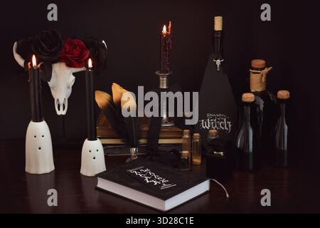 Stilleben im Halloween-Stil mit Hexendekor: Tränke, Bücher und Kerzen Stockfoto