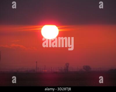 Spektakulärer Sonnenuntergang über den Rodopi Bergen, Ostgriechenland. Dramatischer Himmel mit orangefarbenen Wolken und fernem Horizont. Stockfoto