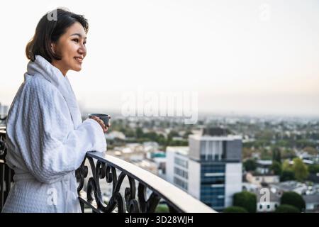 Frau genießt Kaffee auf ihrem Balkon in LA Stockfoto
