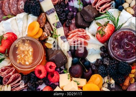 Nahaufnahme einer farbenfrohen Wurstplatte mit Aufschnitt, Käse und Obst. Stockfoto