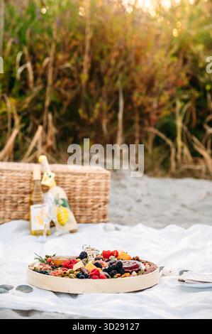 Wurstplatte mit Wein und Limoncello auf einem Picknick am Strand Stockfoto