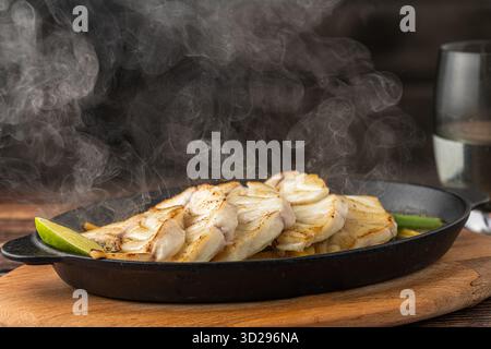 Gegrilltes Wolfsbarschfilet, serviert auf einer Pfanne mit Gemüse Stockfoto