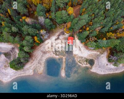Luftaufnahme des roten Bootshauses hoch und trocken am Ufer des Loch VAA in der Nähe von Aviemore mit sehr niedrigen Wasserständen, Aviemore, Schottland, Großbritannien Stockfoto