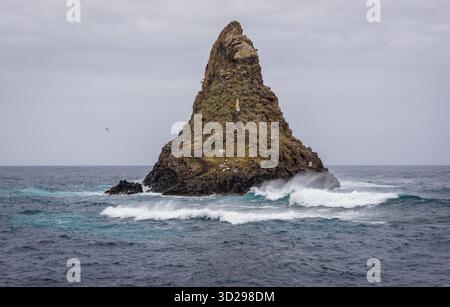 Eine der Inseln der Zyklopen mit einem kleinen Schrein vom Ufer des Ionischen Meeres im Meer aus gesehen Stapel der Zyklopeninseln in ACI Trezza, einer Frazione von ACI Stockfoto