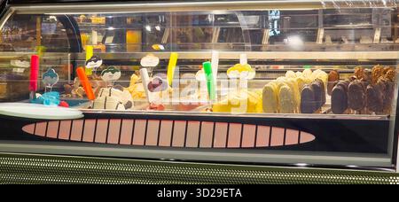 Doloman, Türkei - 25. April 2025: Farbenfrohe Eisdielen in einem modernen Geschäft mit verschiedenen Geschmacksrichtungen und Leckereien. Stockfoto