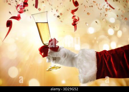 Silvester-Dinner-Konzept mit der Hand des Weihnachtsmanns, die ein Glas Sekt auf einem Hintergrund mit goldenem Bokeh hält Stockfoto