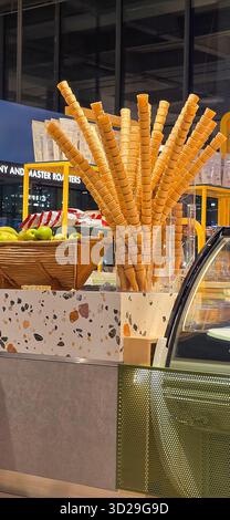 Doloman, Türkei - 25. April 2025: Eiskegel stehen neben frischen Äpfeln in einem modernen Dessertgeschäft. Stockfoto