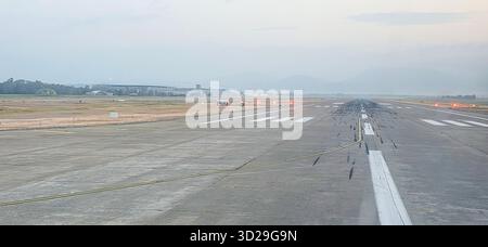 Doloman, Türkei - 25. April 2025: Blick auf die Start- und Landebahn des Flughafens mit Lichtern, die die Oberfläche und die Berge dahinter beleuchten. Stockfoto