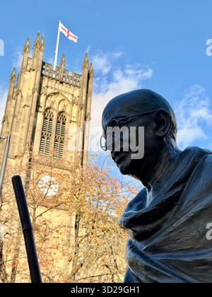 Nahaufnahme der Statue von Mahatma Gandhi mit der Kathedrale von Manchester im Hintergrund im Stadtzentrum von Manchester Stockfoto