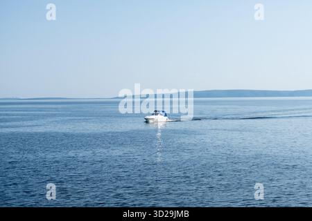 Eine kleine Yacht segelt entlang des wunderschönen und breiten Wolga-Flusses in der Stadt Tolyatti. Der breite Fluss bietet einen wunderschönen Blick auf die Hügel. Stockfoto