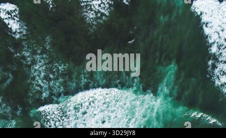 Luftdrohnenfoto mit türkisblauem Wasser der Atlantikküste in Portugal mit Meereswellen. Blick von oben auf natürliche Strukturen und Farben des Ozeans. Ba Stockfoto