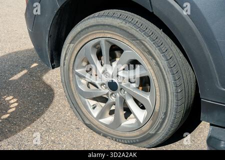 Fahrzeugreifen und Felge auf Asphalt zeigen Verschleiß durch Fahren und Straßenfahrten. Banff, ab Stockfoto