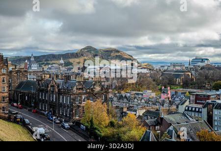 Blick vom Edinburgh Castle aus mit Blick auf die bezaubernden Gebäude mit Arthur's Seat, der im Hintergrund im sanften Herbstlicht steht Stockfoto