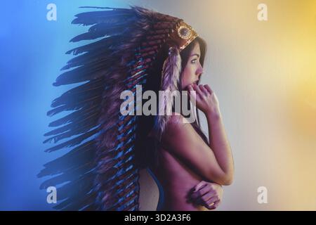 Schöne junge Brünette mit großen Indianische Feder der braunen Federn. hat lange schwarze Haare Stockfoto