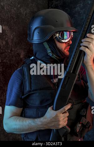 Dieb, bewaffneter Mann mit Sturmhaube und kugelsichere Weste, Pistole und Schrotflinte, kalaschnikow Stockfoto