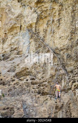 Niedrigwinkelaufnahme eines jungen Mannes beim Sportklettern im Canadon de la buitrera Canyon, Piedra Parada Stadt, patagonia, chubut Provinz, Argentin Stockfoto