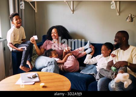 Glückliche, multirassische Familie, die zu Hause Freizeit genießt Stockfoto
