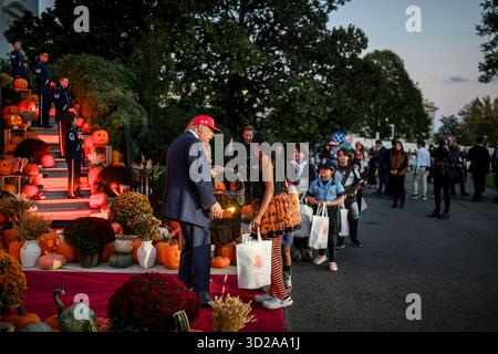 Washington, Usa. 30. Oktober 2025. US-Präsident Donald Trump und First Lady Melania Trump begrüßen Kinder während der jährlichen Halloween-Trick-or-Treat-Veranstaltung auf dem Südrasen des Weißen Hauses, 30. Oktober 2025, in Washington, DC Credit: Daniel Torok/White House Photo/Alamy Live News Stockfoto