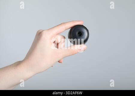 Frau mit versteckter Spionageschiene auf hellgrauem Hintergrund, Nahaufnahme Stockfoto