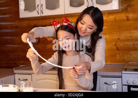 Mutter und Tochter machen zusammen Weihnachtskekse Stockfoto
