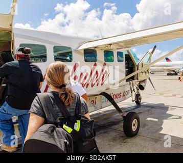 Weiblicher Reisender, der ein kleines Pendlerflugzeug am Daniel K. Inouye International Airport, Honolulu, Oahu, Hawaii, USA verlädt Stockfoto