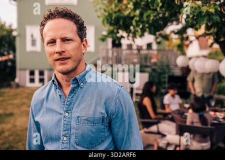 Porträt eines selbstbewussten Mannes, der im Hinterhof Denimhemd trägt Stockfoto