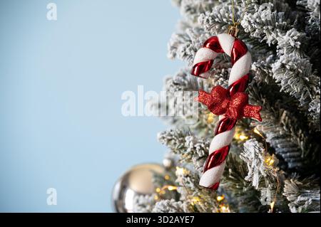 Weihnachtsbaumschmuck auf verschneite Kiefer auf blauem Hintergrund. Stockfoto