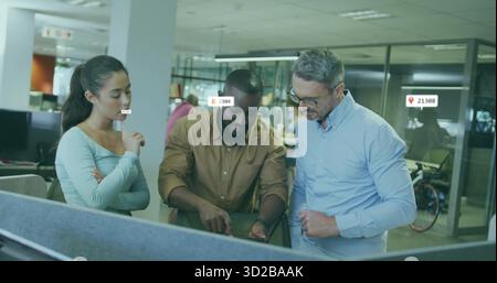 Zusammenarbeit mit Kollegen, die die Konstruktion auf einem großen Monitor in Großraumbüros mit Tischteiler überprüfen Stockfoto