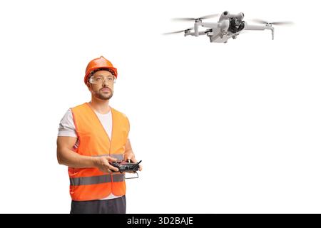 Drohnenfahrer in einer reflektierenden Weste und Helm fliegen eine Drohne isoliert auf weißem Hintergrund Stockfoto