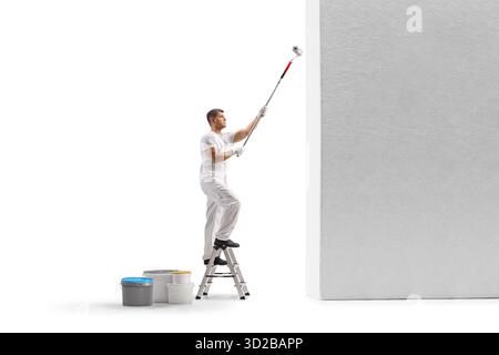 Maler auf einer Leiter, der eine Wand mit einer Rolle auf weißem Hintergrund malte Stockfoto