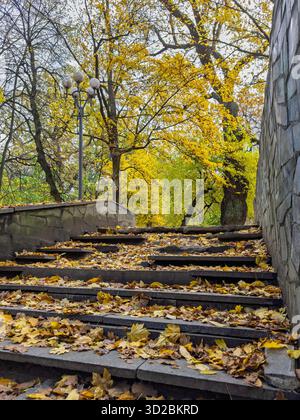 Herbsttreppe im Stadtpark mit goldenen Blättern während des Herbstnachmittags Stockfoto