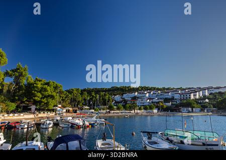 NECUJAM, KROATIEN, 09.01.2025: Ein ruhiges Dorf am Meer mit weiß getünchten Häusern auf einem Hügel, einem Kiesstrand und Booten, die in einem ruhigen Hafen angedockt sind Stockfoto