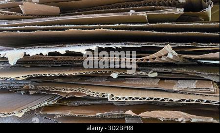 Kartonkisten im Hintergrund gestapelt. Stapeln von gebrauchter Pappe zum Recycling. Vollformatfoto, horizontales Format Stockfoto