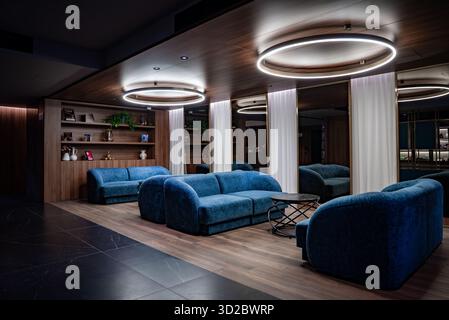 Moderne Hotellounge in Mellieha mit blauen Samtsofas am Abend Stockfoto