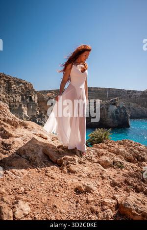 Frau auf Rostfelsen über der Blauen Lagune, Comino Island, Malta Stockfoto