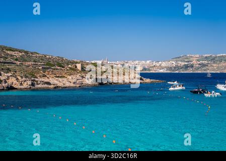 Blaue Lagune auf Comino Island, Malta mit Booten und Kalksteinklippen Stockfoto