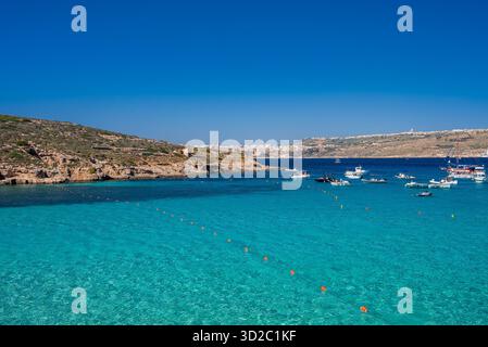 Blaue Lagune auf Comino, Malta mit Booten, Schwimmern und Klippen Stockfoto