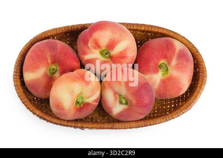 chinesische flache Donut-Pfirsiche in einem Korb isoliert auf weißem Hintergrund. Draufsicht. Flache Lagen Stockfoto