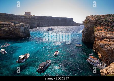 Blaue Lagune in Comino, Malta mit Booten, Schwimmern und St. Mary's Tower Stockfoto