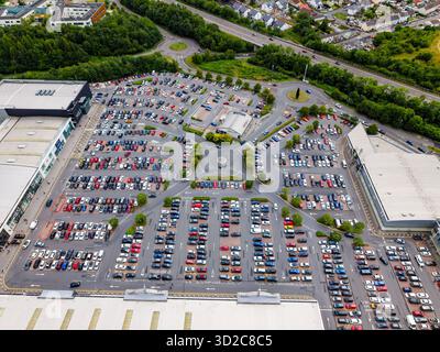 Merthyr Tydfil - 19.07.2025: Hochwinkeldrohne, die Hunderte von Autos auf einem Parkplatz des Einkaufszentrums zeigt. Stockfoto