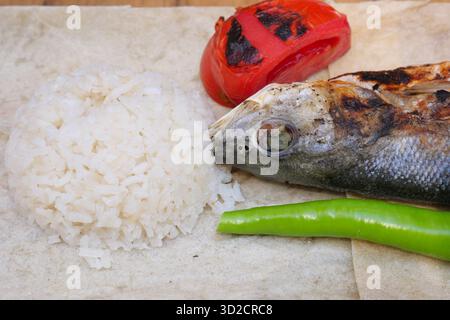Gegrillter Fisch, Reis und Gemüse auf einem Teller Stockfoto