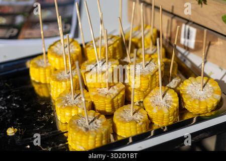 Selektiver Fokus geschnitten ​​yellow Mais gekocht und gekocht auf vielen Spießen in einem Tablett. Anbieter garantieren die Frische und Süße der Maissorten Stockfoto