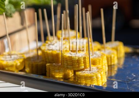 Selektiver Fokus geschnitten ​​yellow Mais gekocht und gekocht auf vielen Spießen in einem Tablett. Anbieter garantieren die Frische und Süße der Maissorten Stockfoto