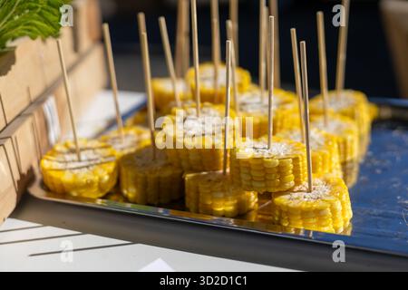 Selektiver Fokus geschnitten ​​yellow Mais gekocht und gekocht auf vielen Spießen in einem Tablett. Anbieter garantieren die Frische und Süße der Maissorten Stockfoto