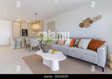 Moderne, offene Lounge mit neutralen Farbtönen, gemütlichen Möbeln und natürlichen Dekorationen Stockfoto
