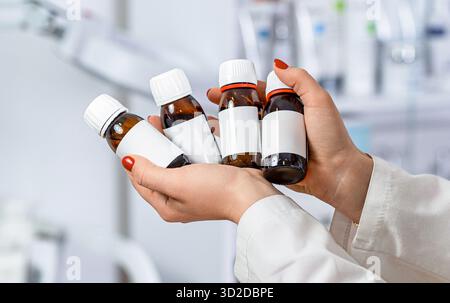 Leeres Etikett, Frauenhände halten Flaschen. Arzt halten Sie die Durchstechflasche mit der Impfstoffflasche im Labor. Doktor Hand hält die Glasflaschen Stockfoto