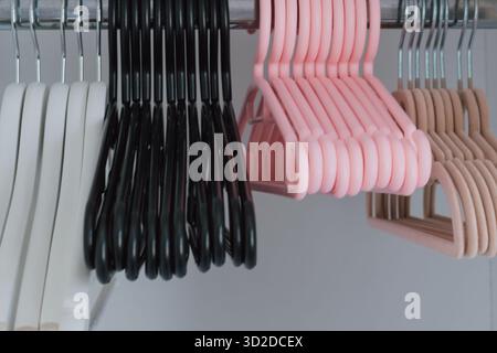 Verschiedene Sets von Kleiderbügeln in Kleiderschränken in verschiedenen Formen, Materialien und Farben Stockfoto