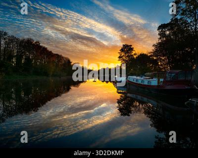 Blick vom Fußweg über das Abingdon Weir an der Themse, spektakulärer Wintersonnenaufgang Abingdon-on-Thames behauptet, die älteste Stadt Englands zu sein. Und die Themse fließt durch ihr Herz. In dieser idyllischen Szene sehen wir von den Abingdon Locks aus einen recht schönen Blick auf den Fluss, gerade während die Sonne an einem schönen Wintermorgen aufgeht. So ruhig... Stockfoto